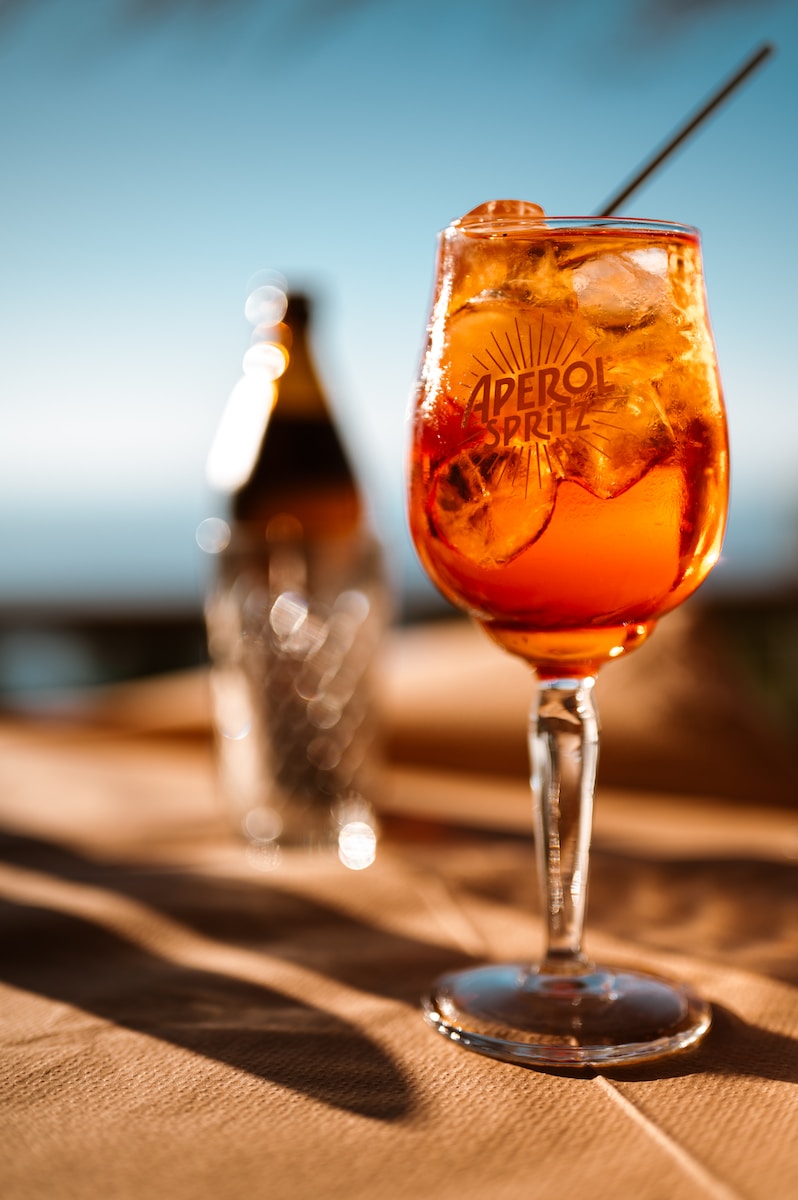 a glass of alcohol sitting on top of a wooden table